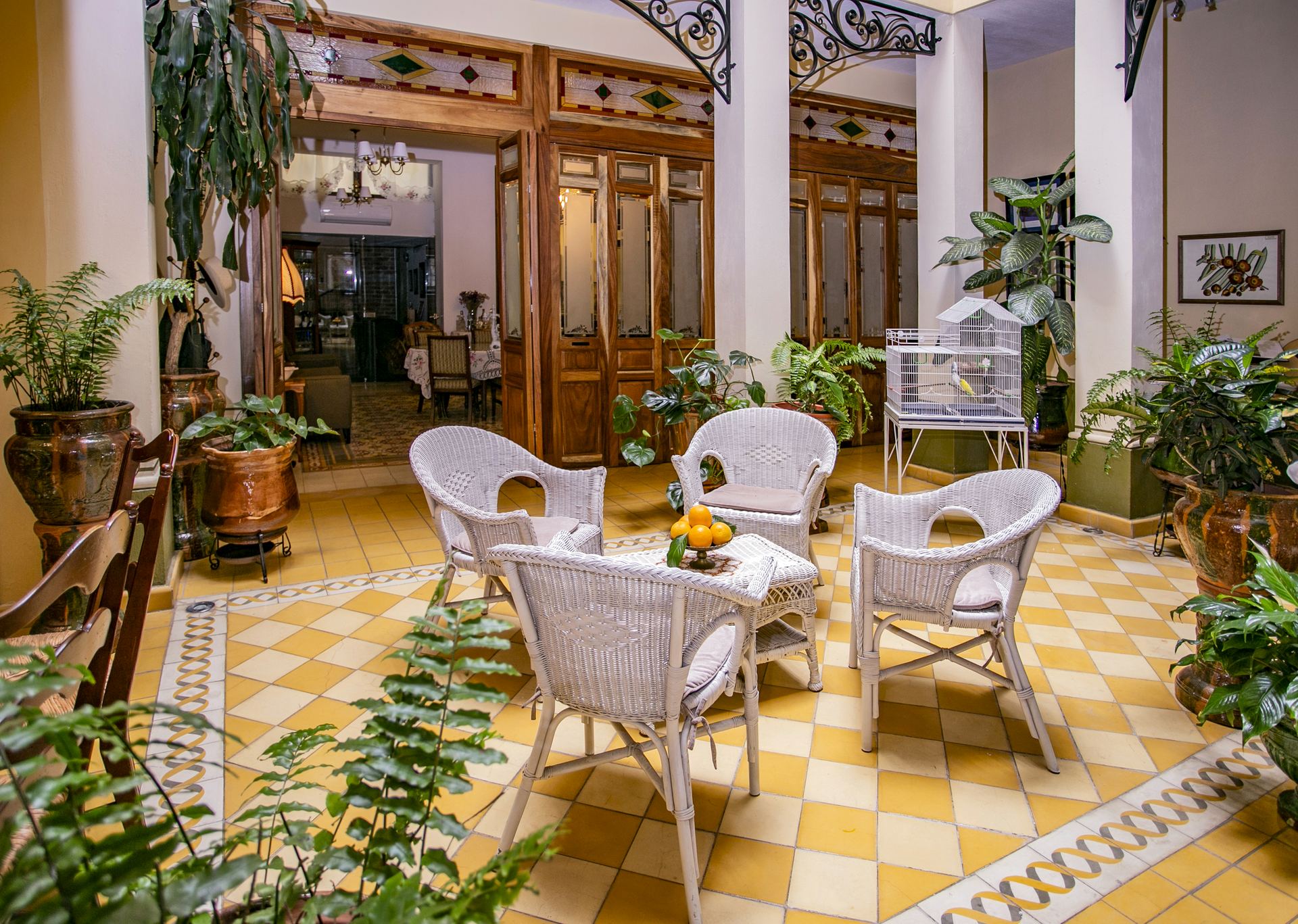 Grand Casa Naranjos corridor with wicker chairs and oranges